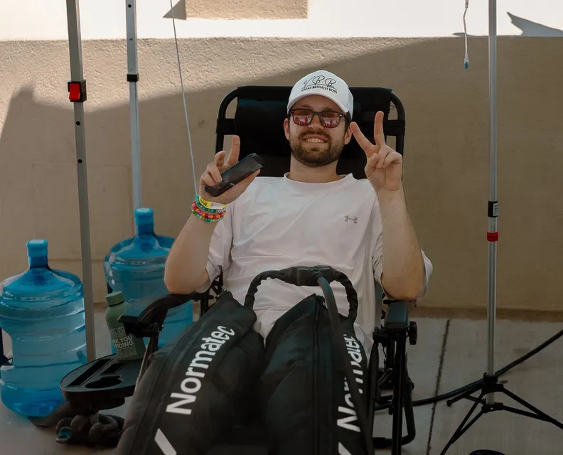 A client relaxing in a recliner with compression boots during a treatment.
