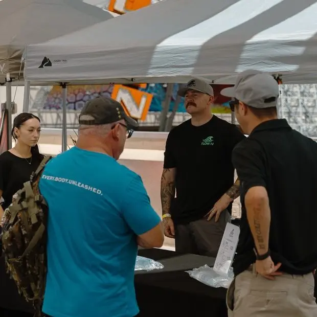 Flow IV team members talking with a visitor at the company's booth in downtown Las Vegas.