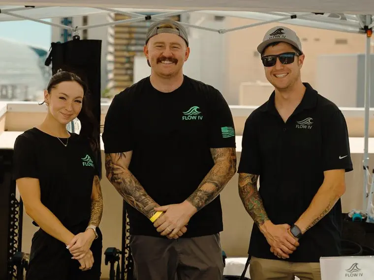 Three members of the Flow IV team at their event booth in Las Vegas.