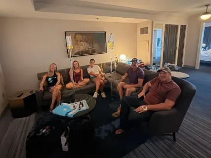 A group receiving IV therapy in a hotel lounge seating area.
