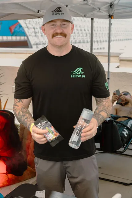A Flow IV team member holding supplies at the company's event booth.